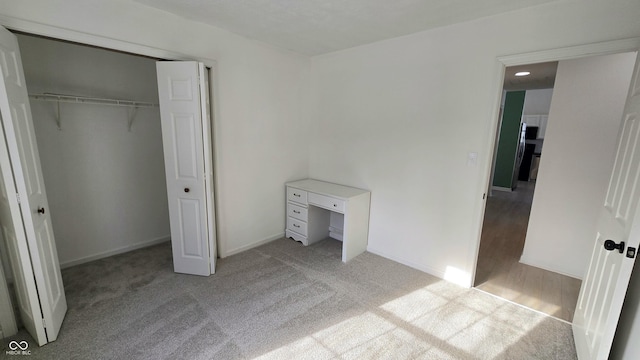 unfurnished bedroom with a closet and light carpet