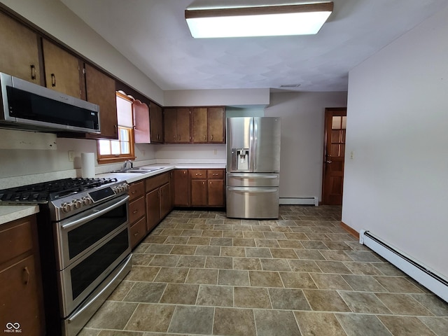 kitchen featuring baseboard heating, stainless steel appliances, dark brown cabinets, and sink