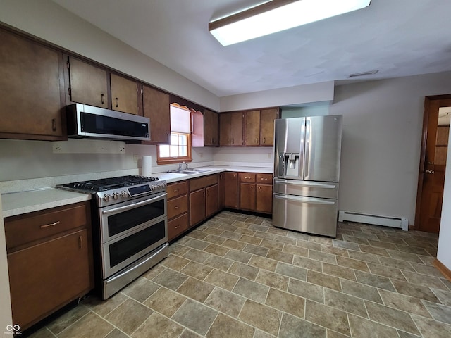 kitchen featuring baseboard heating, sink, stainless steel appliances, and dark brown cabinetry