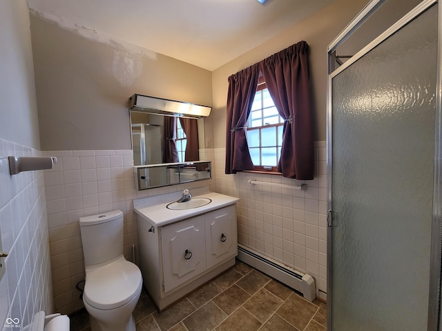 bathroom with a shower with shower door, baseboard heating, tile walls, and vanity