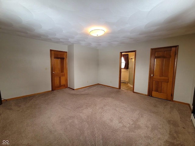 carpeted empty room featuring a baseboard radiator