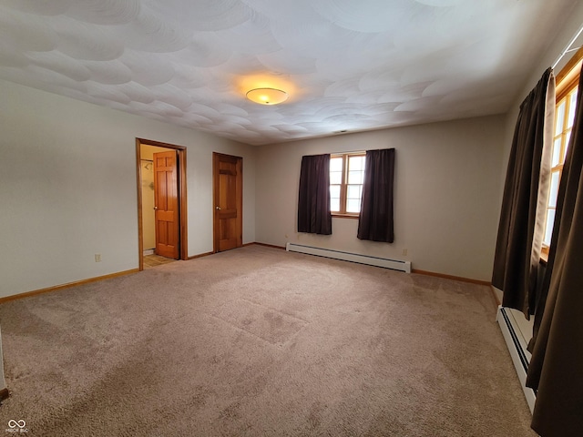 unfurnished bedroom featuring light colored carpet, a baseboard heating unit, and ensuite bathroom