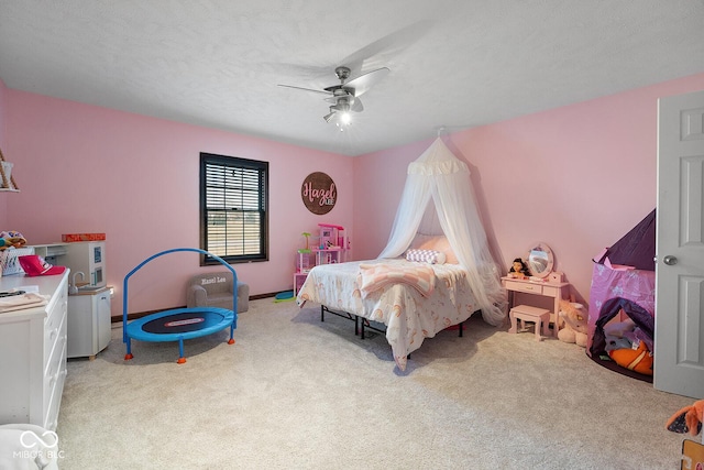 carpeted bedroom with ceiling fan and a textured ceiling