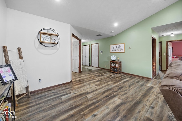 living room with dark hardwood / wood-style flooring and lofted ceiling