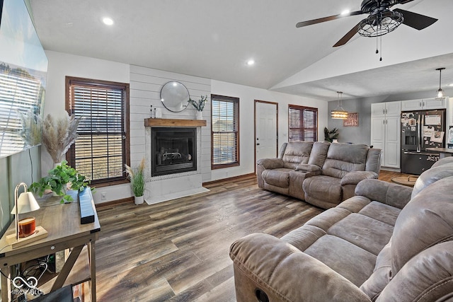 living room featuring a fireplace, plenty of natural light, dark wood-type flooring, and lofted ceiling