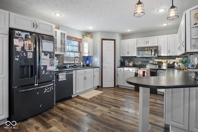 kitchen featuring appliances with stainless steel finishes, tasteful backsplash, white cabinetry, hanging light fixtures, and sink