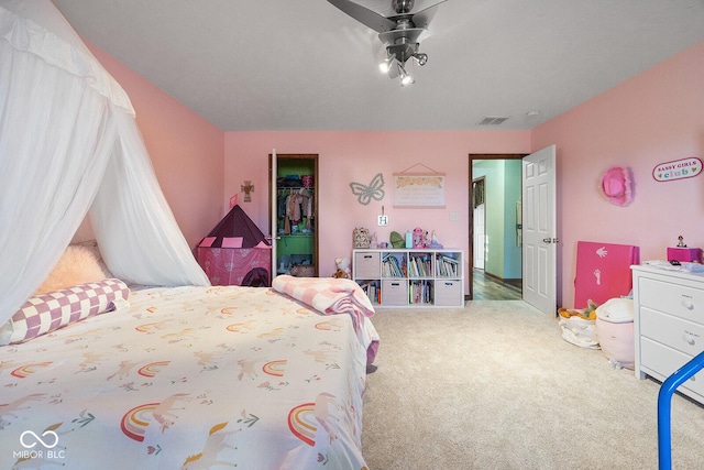 bedroom with carpet floors, a closet, a spacious closet, and ceiling fan