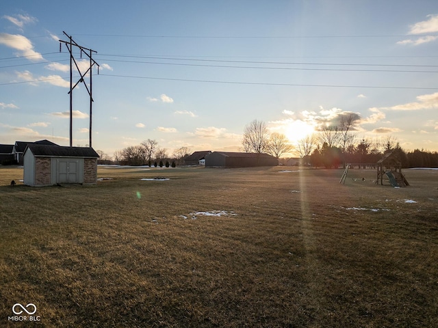 yard at dusk with a playground and a storage shed