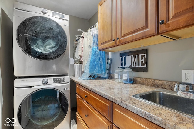 laundry room with cabinets, sink, and stacked washer and dryer