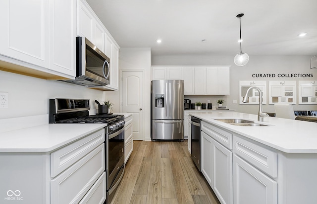 kitchen featuring sink, white cabinetry, stainless steel appliances, and a kitchen island with sink