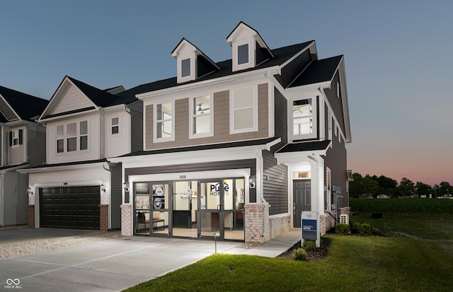 view of front of property with a garage and a lawn