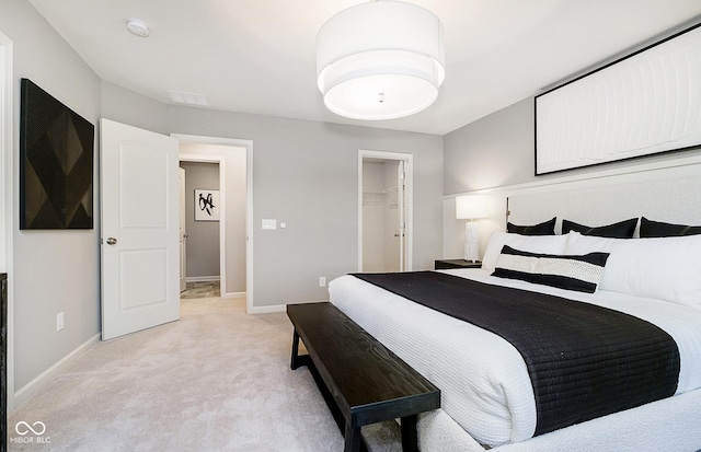 carpeted bedroom featuring a closet and a walk in closet