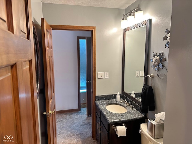 bathroom featuring toilet, vanity, and a textured ceiling