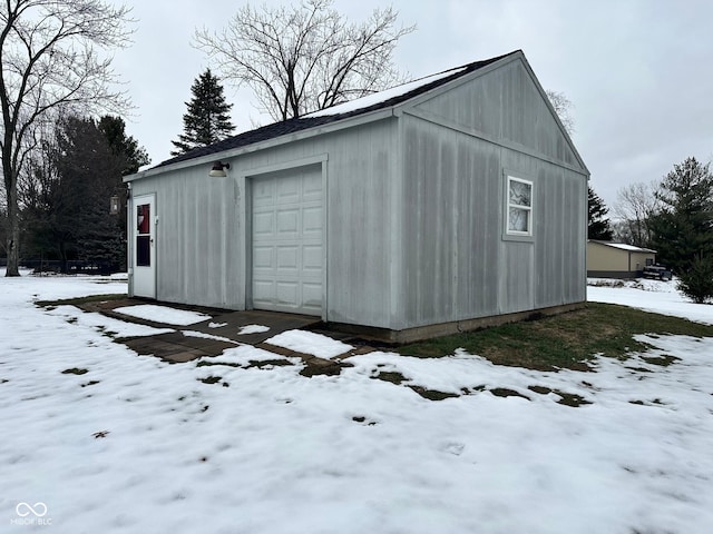 snow covered structure featuring a garage