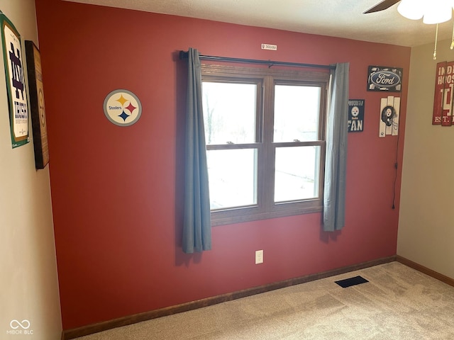 carpeted empty room featuring ceiling fan