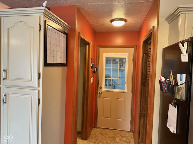 doorway to outside featuring a textured ceiling