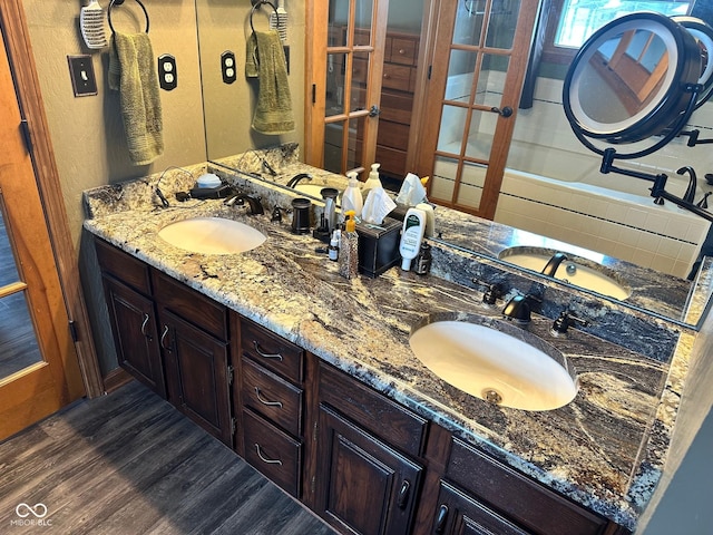 bathroom featuring hardwood / wood-style floors, a tub to relax in, and vanity