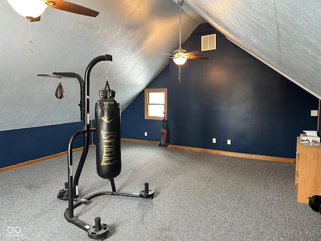 exercise area featuring lofted ceiling, ceiling fan, and a textured ceiling