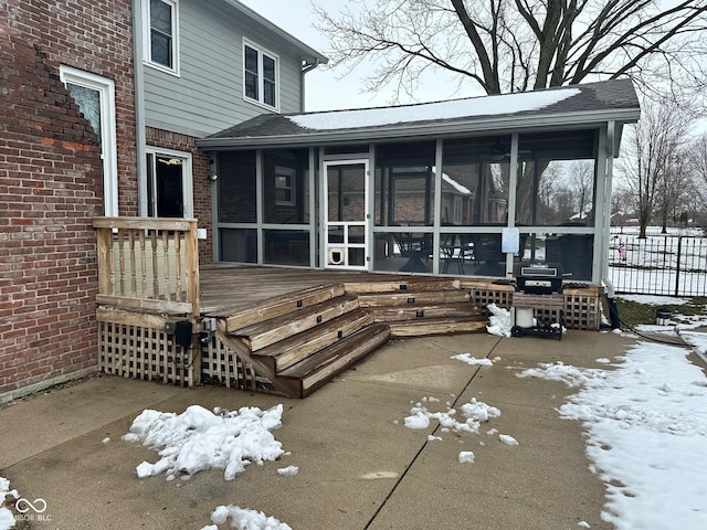 snow covered deck with a sunroom