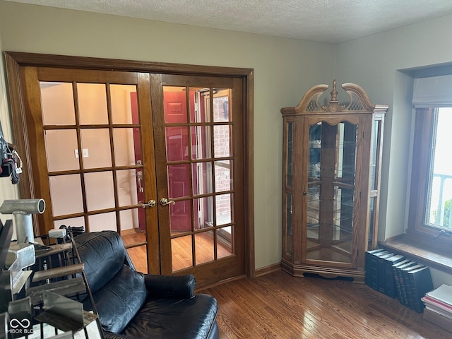 doorway featuring hardwood / wood-style flooring, a textured ceiling, and french doors