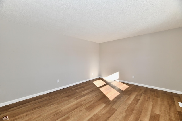 spare room with wood-type flooring and a textured ceiling