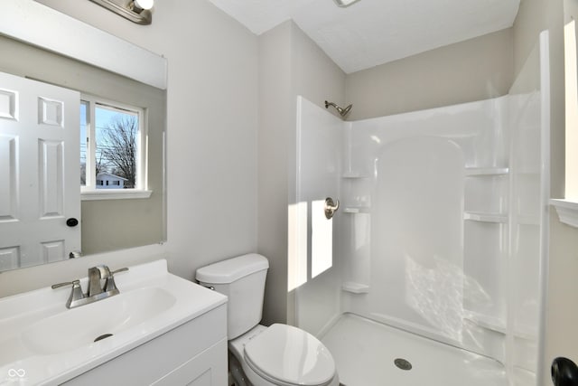 bathroom featuring toilet, walk in shower, and vanity