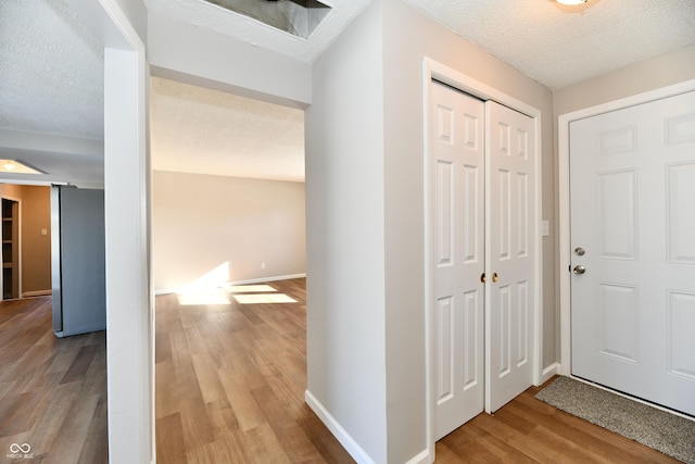 hallway featuring a textured ceiling and light hardwood / wood-style floors