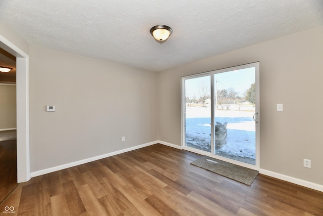 spare room featuring hardwood / wood-style floors and a textured ceiling