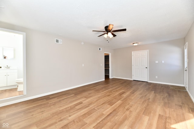 empty room with ceiling fan, sink, a textured ceiling, and light hardwood / wood-style flooring