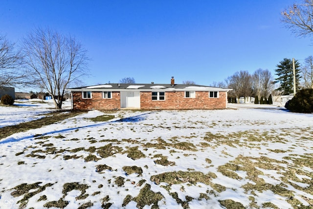 view of snow covered back of property