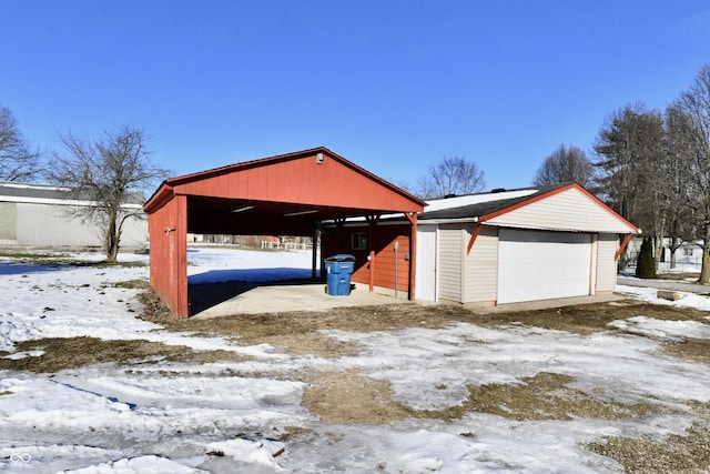 snow covered garage featuring a carport