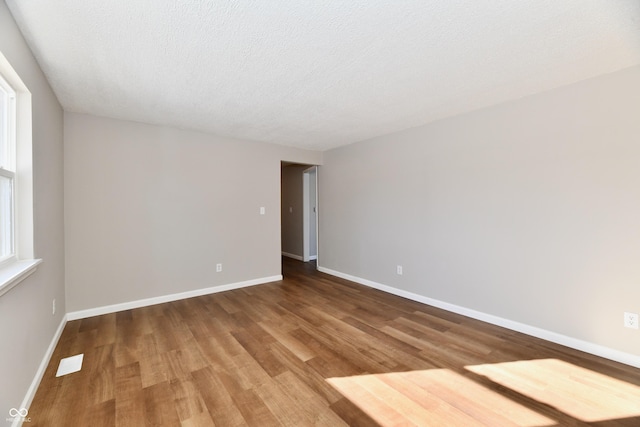 unfurnished room featuring a textured ceiling and hardwood / wood-style flooring