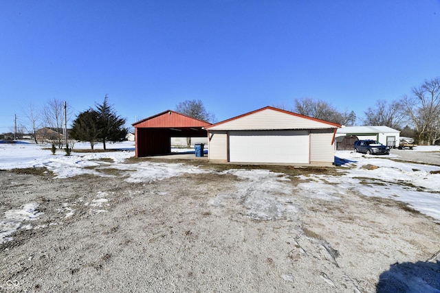 snow covered garage featuring a carport