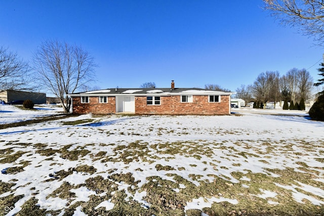 view of snow covered back of property