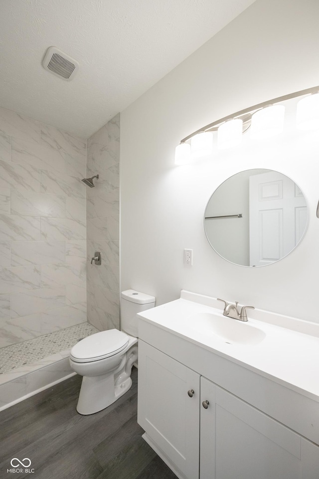 303 Doe Creek Dr, Cloverdale, IN 46120 - full bath featuring toilet, vanity, tiled shower, and wood finished floors