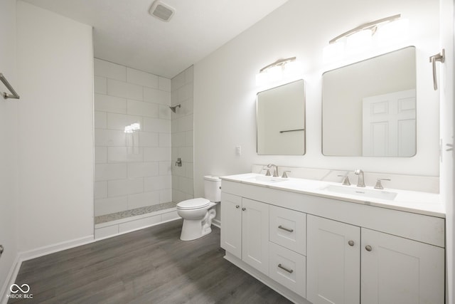 303 Doe Creek Dr, Cloverdale, IN 46120 - full bath featuring toilet, tiled shower, double vanity, and wood finished floors
