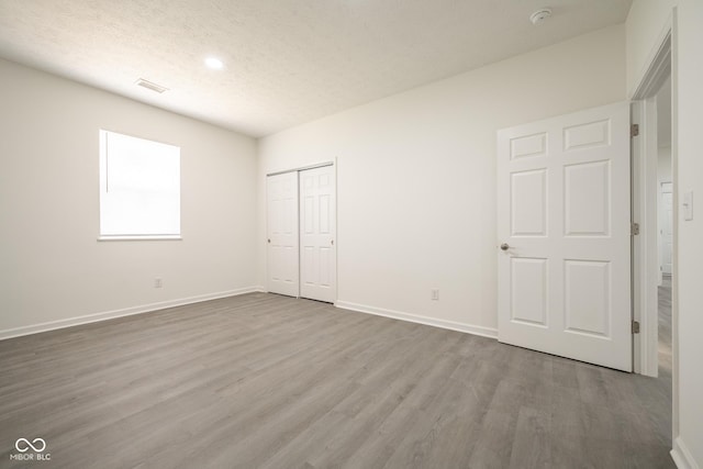 303 Doe Creek Dr, Cloverdale, IN 46120 - unfurnished bedroom featuring wood finished floors, baseboards, a textured ceiling, a closet, and recessed lighting