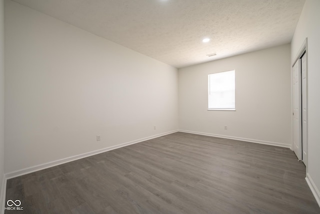 303 Doe Creek Dr, Cloverdale, IN 46120 - unfurnished bedroom featuring dark wood-style floors, baseboards, a textured ceiling, a closet, and recessed lighting