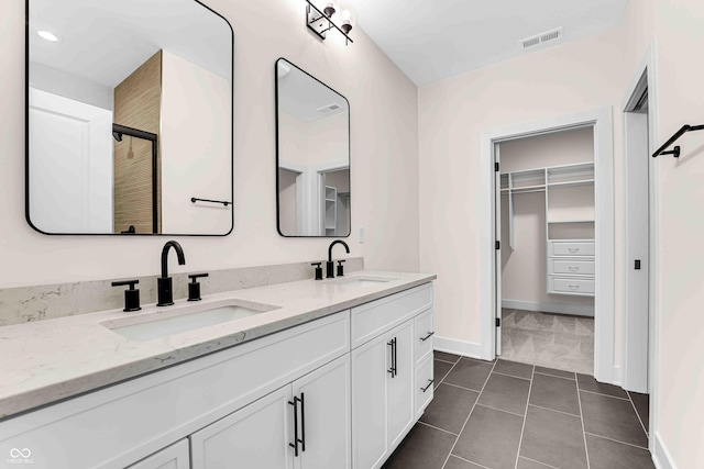 bathroom featuring a shower with door, tile patterned floors, and vanity