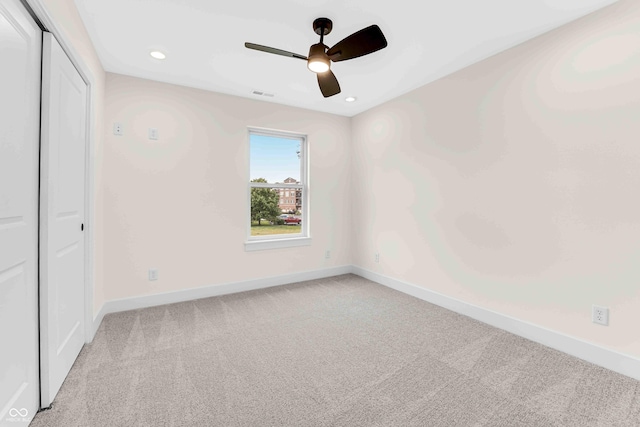 carpeted spare room featuring ceiling fan