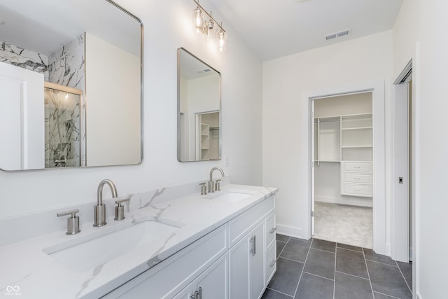 bathroom featuring tile patterned floors, vanity, and walk in shower