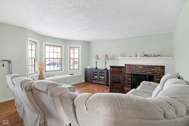 2934 S Irwin St, Indianapolis, IN 46203 - living area featuring wood finished floors, baseboards, a textured ceiling, and a brick fireplace