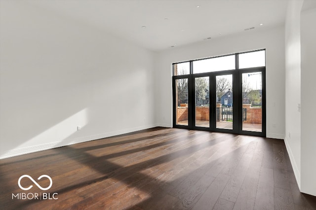 spare room featuring dark wood-type flooring and french doors