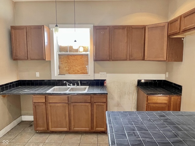 kitchen featuring light tile patterned flooring, sink, and decorative light fixtures