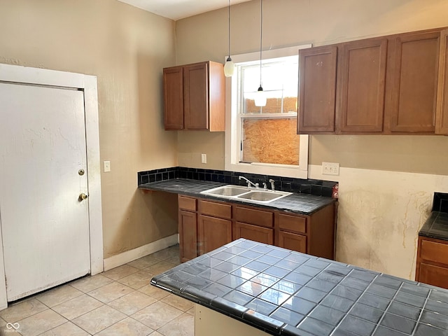 kitchen featuring pendant lighting, sink, tile countertops, and light tile patterned floors