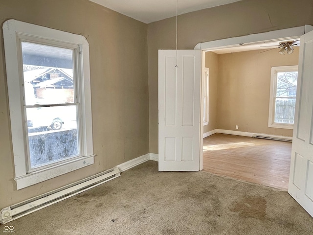 carpeted empty room featuring a baseboard radiator and ceiling fan