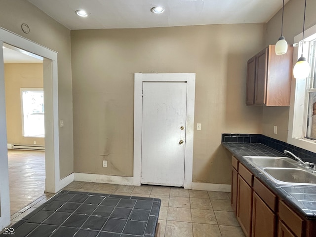 kitchen with a baseboard radiator, sink, pendant lighting, and tile patterned floors