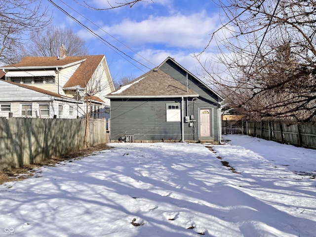 view of snow covered back of property