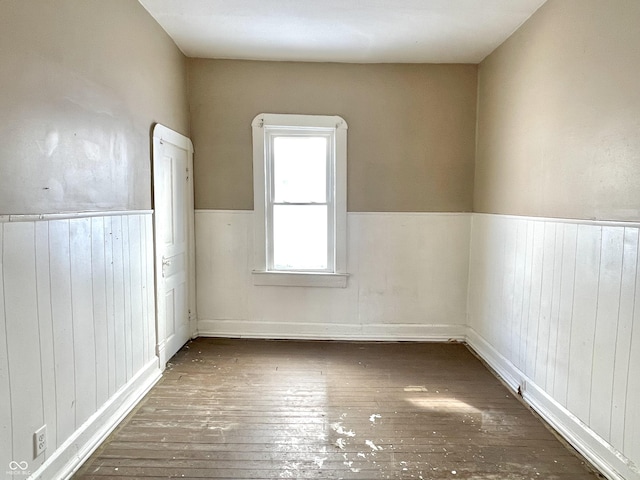 empty room featuring wooden walls and dark hardwood / wood-style floors