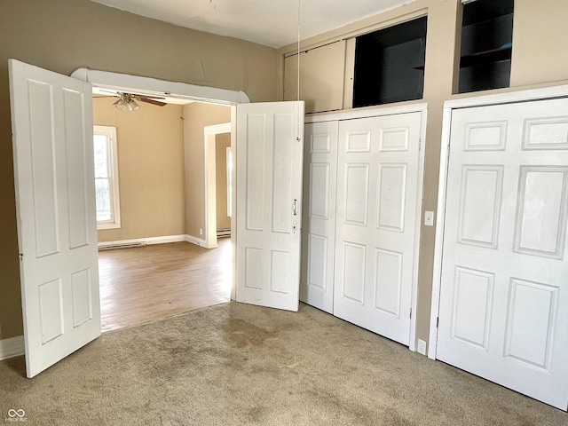 unfurnished bedroom featuring a baseboard radiator, ceiling fan, and carpet flooring